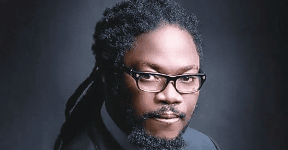 Daddy Showkey performing on stage with a microphone, vibrant lights in background