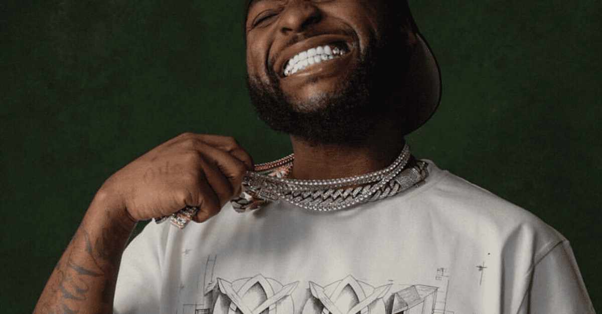 Davido performing on stage with microphone in hand